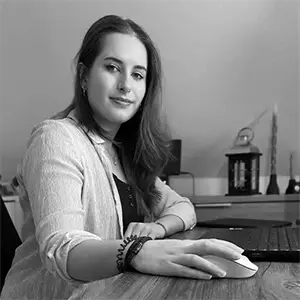 Schwarz-Weiß-Portrait von Celina an ihrem Arbeitsplatz als Teambild für die Agentur-Website.